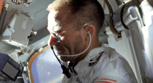 UCLA physics alumn and the first Bruin to travel to space, Walt Cunningham dressed in astronaut uniform in a shuttle setting.