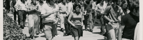 A black and white photograph of students walking through the UCLA campus.