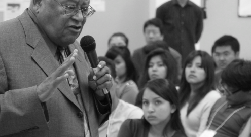 A black and white photograph of Rev. James Lawson Jr., a civil and labor rights icon, giving a lecture in a classroom with students listening attentively.