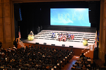 View from balcony of Royce Hall audience and stage during 2024 Humanities commencement ceremony.