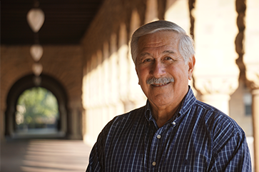 Albert Camarillo, in blue shirt, stands in Royce Hall portico