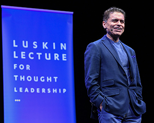 Fareed Zakaria on stage in blue jacket with “Luskin Lecture for Thought Leadership” in background