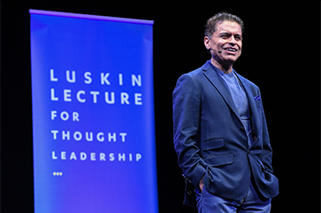 Fareed Zakaria on stage in blue jacket with “Luskin Lecture for Thought Leadership” in background