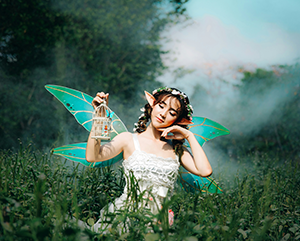 Fairy with green wings in a green meadow