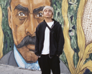 Frank Godinez standing in front of a mural