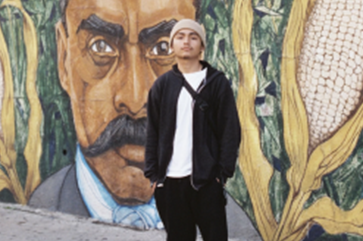 Frank Godinez standing in front of a mural