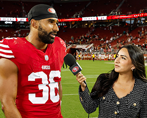 Lindsey Pallares, right, interviewing Curtis Robinson on football field