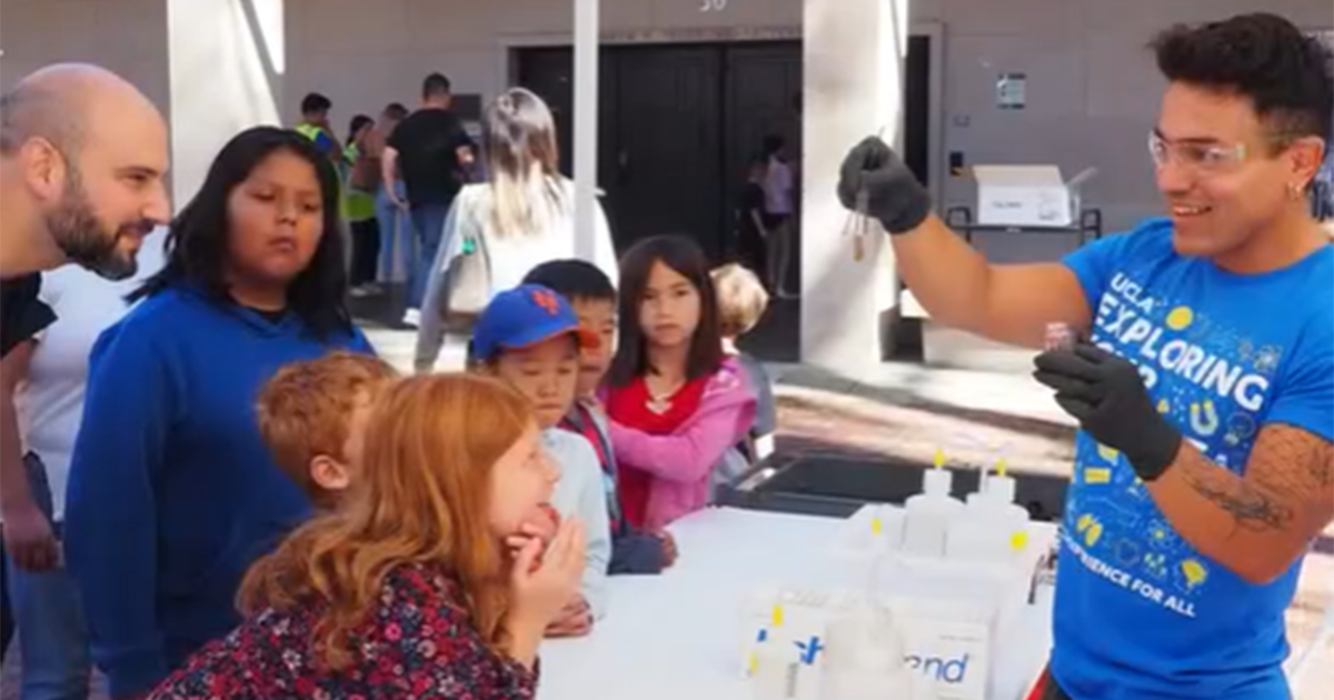 An EYU representative conducting an experiment in front of a group of children.