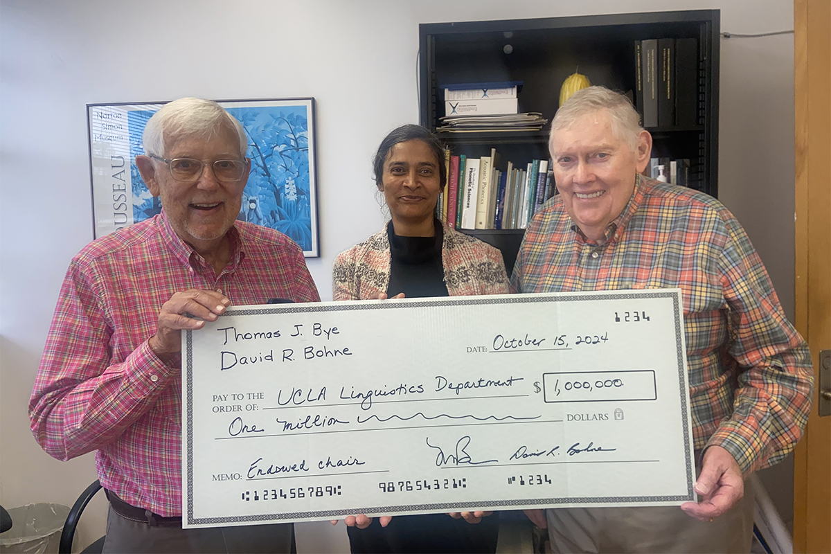 Tom Bye, David Bohne and Megha Sundara holding an oversized check. 