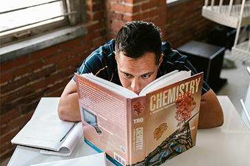 Student reading a chemistry textbook