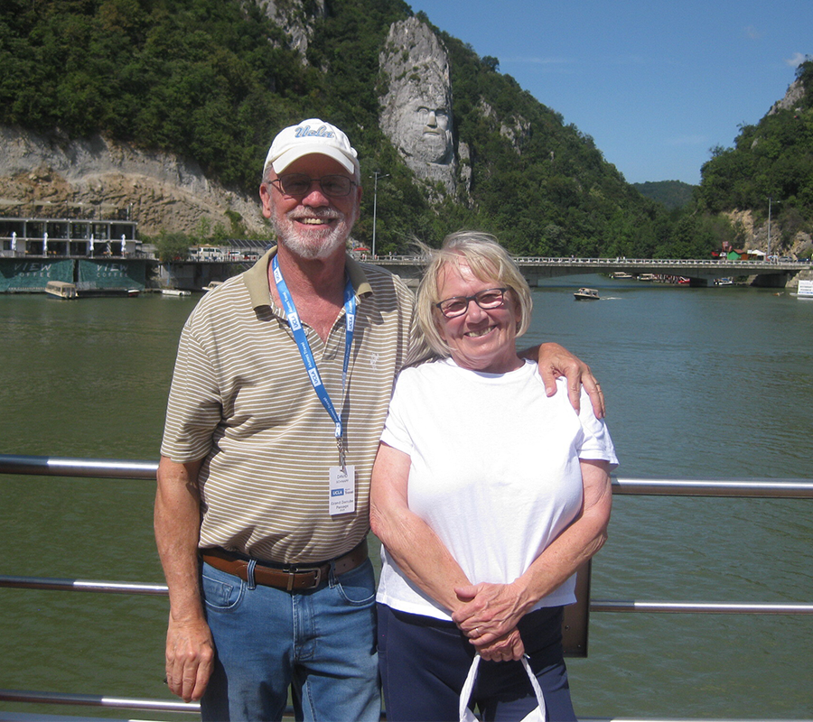 David Schnapp and Karin Cooper in Romania with the rock sculpture of Decebalus in the background. 