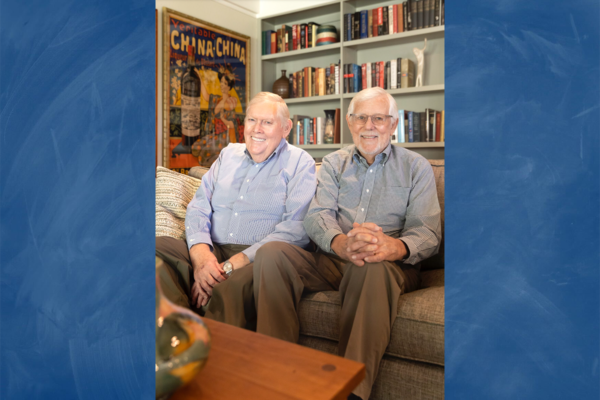 An image of Tom Bye (left) and David Bohne (right) sitting in a room with books and posters superimposed over a blue background. 