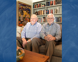 An image of Tom Bye (left) and David Bohne (right) sitting in a room with books and posters superimposed over a blue background.