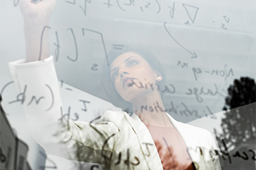 Pri Narang writing math equations on a glass whiteboard.