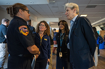 UCLA Chancellor Julio Frenk speaks with a representative of the California Department of Forestry and Fire Prevention at the opening of the disaster recovery center.