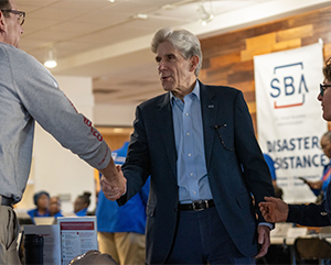 Julio Frenk shaking hands at the disaster recovery center