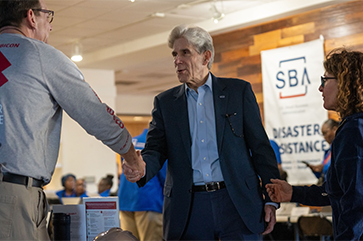 Julio Frenk shaking hands at the disaster recovery center