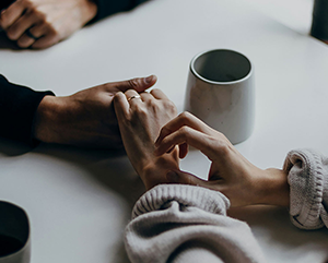 Two people hold hands atop a table