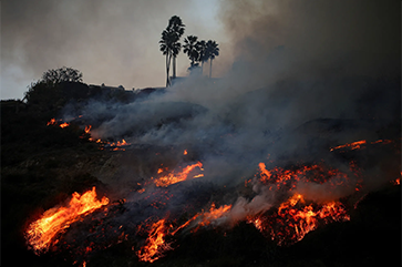 Smoke rises as a wildfire burns in the Pacific Palisades neighborhood of west Los Angeles, California, January 7, 2025.