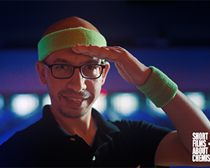 Maher El-Kady in a green headband with a bowling alley in the background.