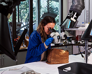 First-year conservation student Fernanda Baxter examines a basket.