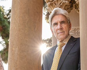 Julio Frenk standing in front of stone columns.