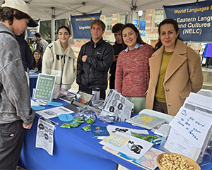 Volunteers with a visitor at the Near Eastern Languages and Cultures table at World Languages Day.