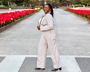 Sonya Brooks walks in a crosswalk across a street lined with red tulips