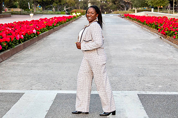 Sonya Brooks walks in a crosswalk across a street lined with red tulips