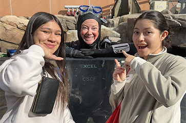 Tara Prescott-Johnson (center) in a water tank at the California Science Center with UCLA students Samantha Calva and Evelyn Cuxeva-Ortega