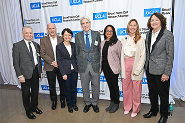 From left: Steven Dubinett, Thomas Rando, Yvonne Chen, UCLA Chancellor Julio Frenk, Aparna Bhaduri, Amander Clark and Judith Gasson stand in front of UCLA Broad Stem Cell Research Center step-and-repeat sign