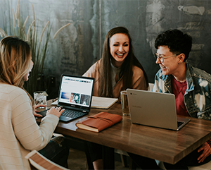 People talking at a communal desk.