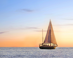 A sailboat on the water at sunset.