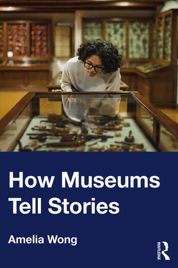 A person with curly hair looks at objects in a glass display case inside a museum. The book cover reads How Museums Tell Stories by Amelia Wong, with wooden display cases in the background.