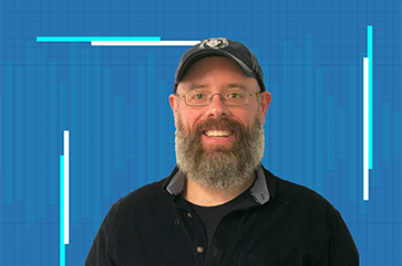 Eric Deeds in a black shirt against a blue grid background