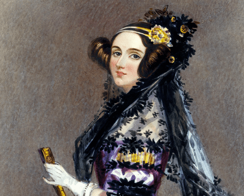 A historical portrait of a woman with brown hair styled in buns, wearing a black lace shawl, a floral headdress, and a purple dress, holding a closed fan, set against a neutral background.