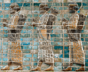 Ancient stone relief showing three armed warriors in profile, wearing detailed robes and headdresses, set against a blue and turquoise tiled background.