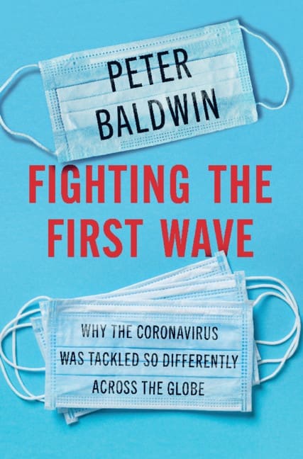 Book cover for Fighting the First Wave by Peter Baldwin, featuring two blue surgical masks on a blue background, with the title and subtitle in bold red and white text overlaid on the masks.